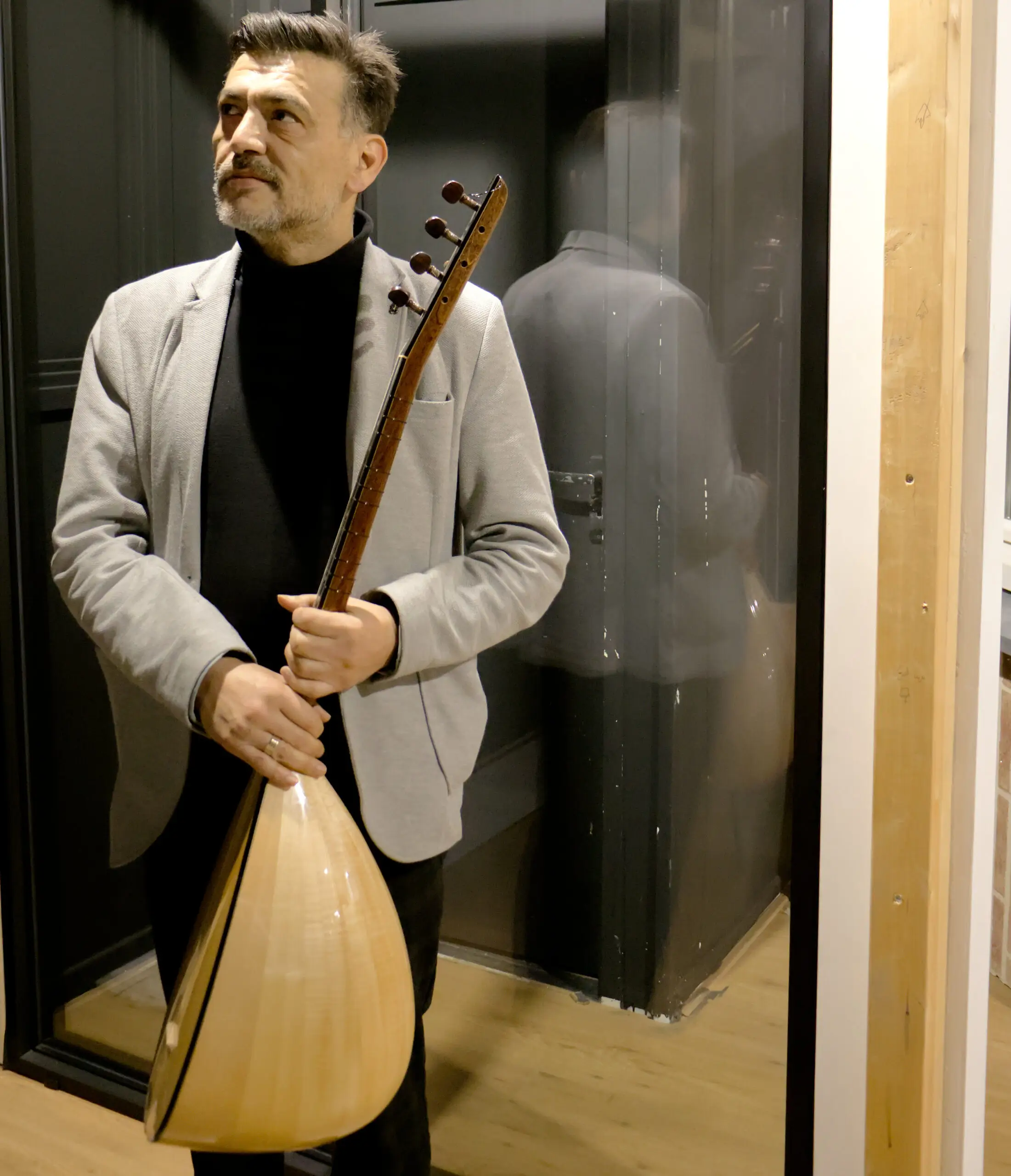 Foto waar Mesut met baglama in zijn handen heeft