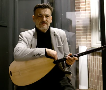 Homepage foto waar Tiryakim met baglama zit.